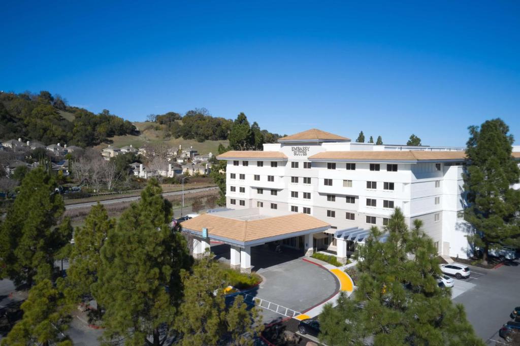 Embassy Suites by Hilton San Rafael Marin County في سان رافائيل: اطلالة علوية على مبنى مع موقف للسيارة