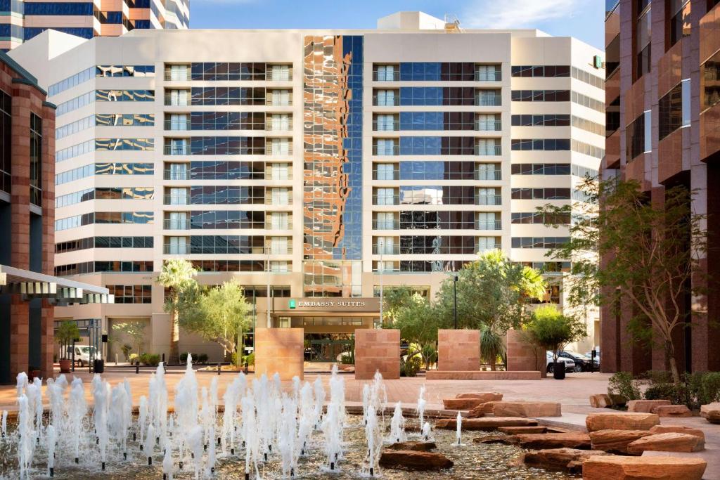 a fountain in the middle of a city with tall buildings at Embassy Suites by Hilton Phoenix Downtown North in Phoenix