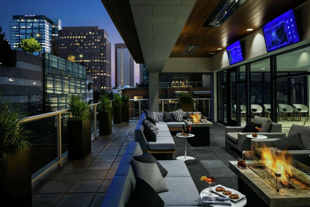 a rooftop patio with couches and a fire pit on a building at Hilton Garden Inn Seattle Bellevue Downtown, WA in Bellevue