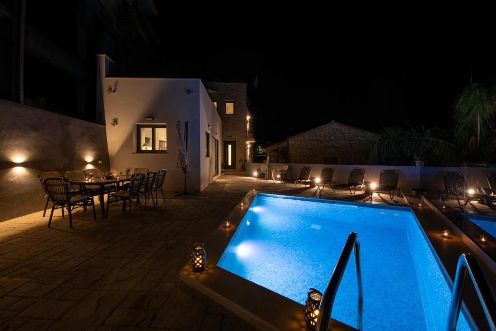 a swimming pool at night with a table and chairs at Villa Ioanna NC , an upper class accommodation in Próvarma