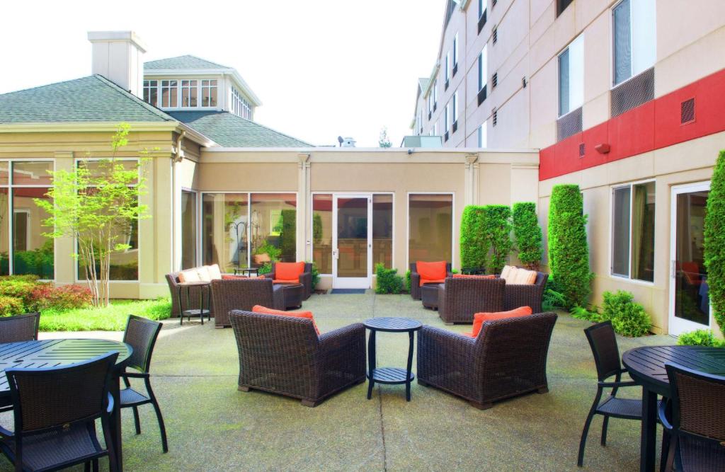 a patio with tables and chairs in a courtyard at Hilton Garden Inn Seattle/Renton in Renton