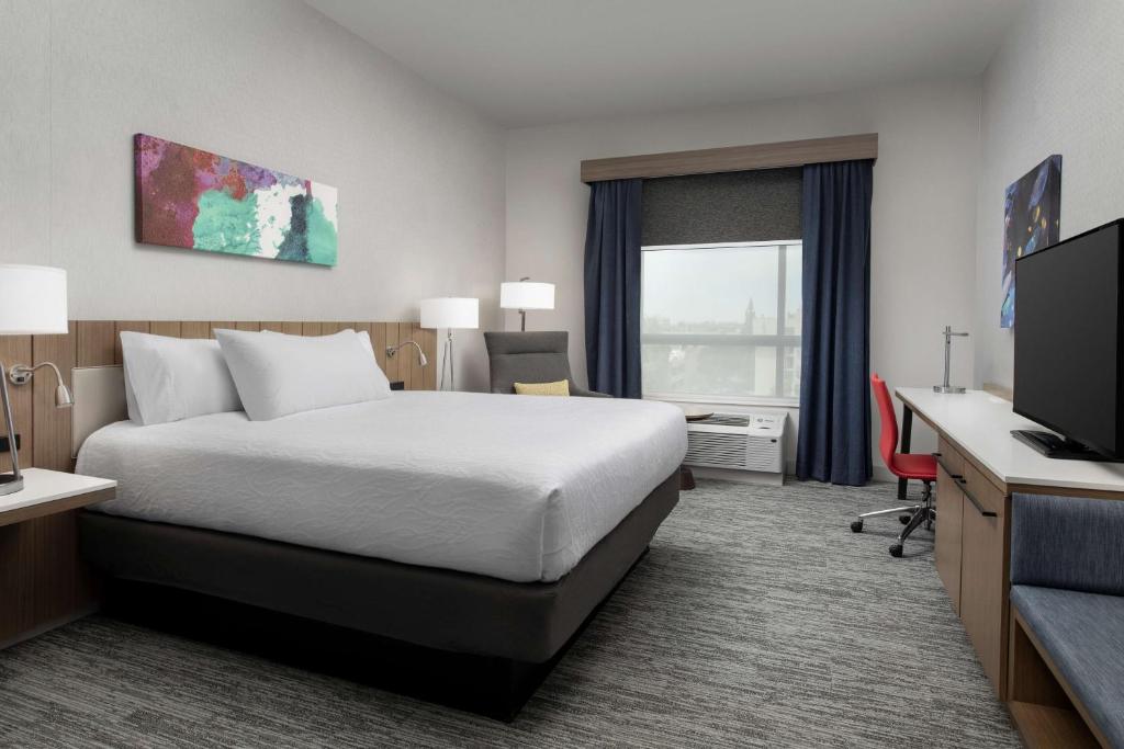 a hotel room with a bed and a television at Hilton Garden Inn San Jose Airport in San Jose