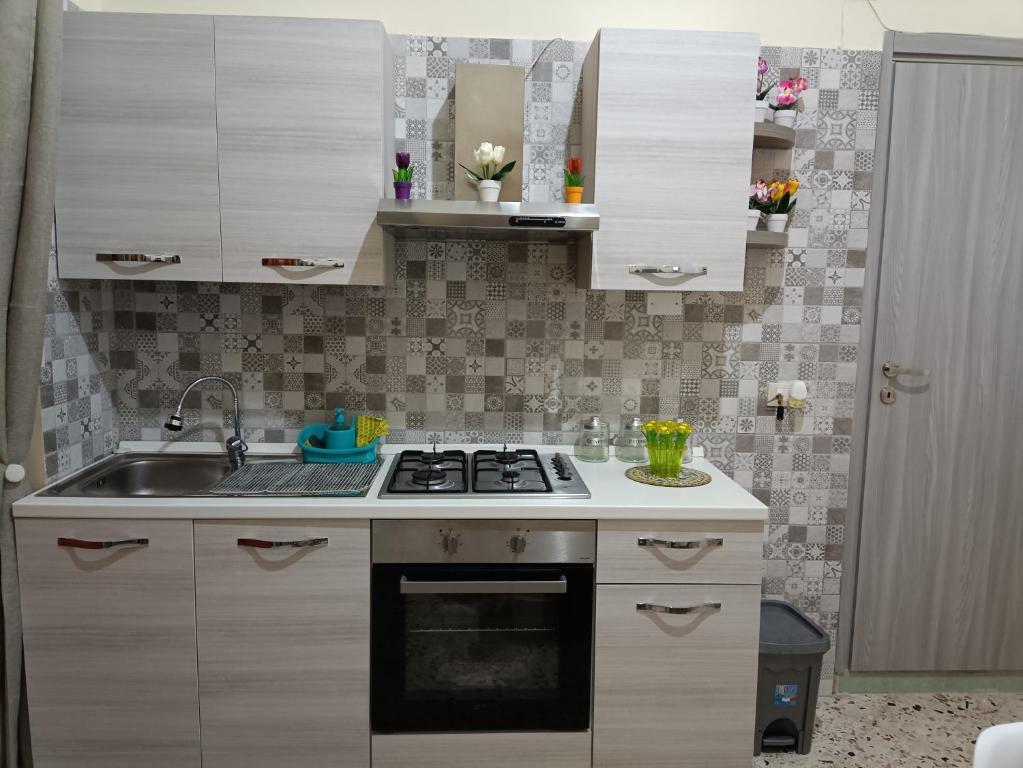 uma pequena cozinha com um fogão e um lavatório em Holiday home La Rinascita em Bagheria