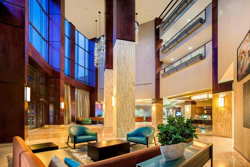 eine Lobby eines Gebäudes mit Stühlen und einer Couch in der Unterkunft Courtyard by Marriott Dallas Allen at Allen Event Center in Allen
