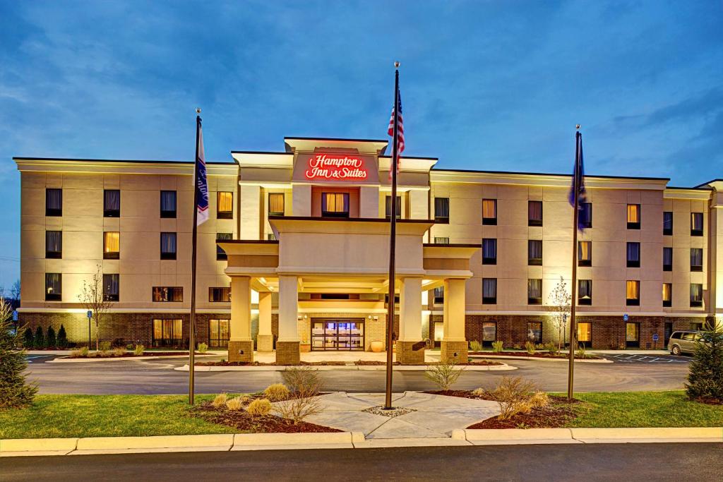 a hotel building with flags in front of it at Hampton Inn & Suites Lansing West in Lansing