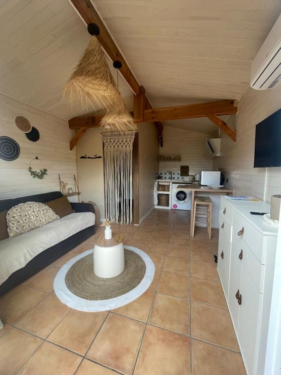 uma sala de estar com um sofá e uma cozinha em Studio chalet Bassin d’Arcachon em Mios