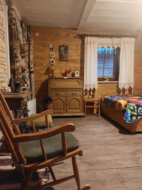 a bedroom with a bed and a wooden wall at Agroturystyka LipoweWzgórze domek Antek in Tereszpol