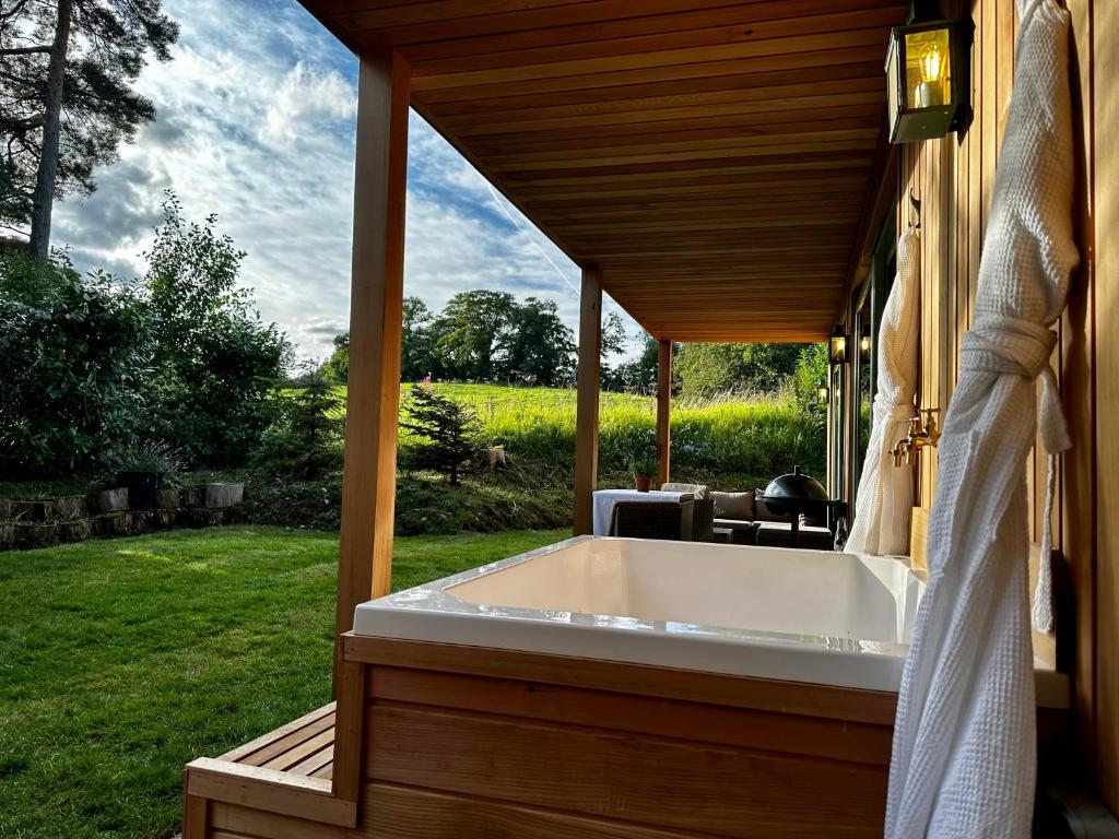 a bath tub on a porch of a house at Peak District Romantic Retreat Outdoor Japanese Whirlpool bath in Stanton in Peak