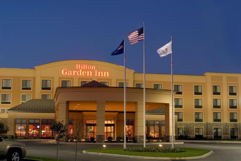 um hotel com duas bandeiras em frente a um edifício em Hilton Garden Inn St. Louis Shiloh/O'Fallon IL em O'Fallon