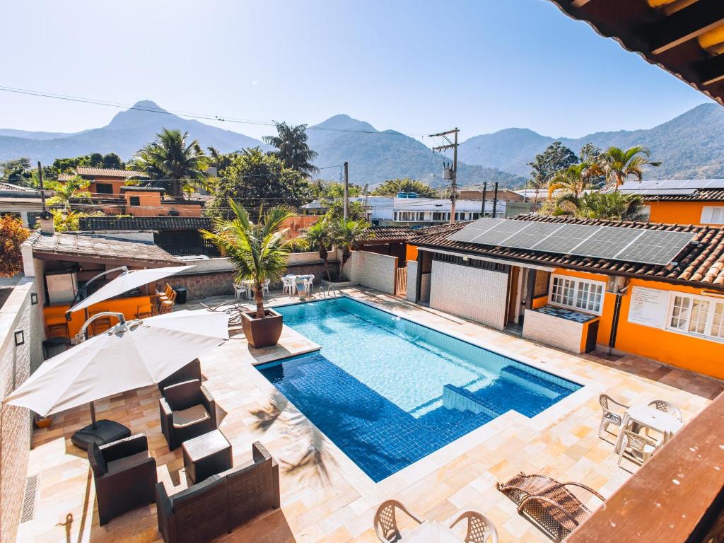 uma piscina no telhado de uma casa com montanhas ao fundo em VELINN Pousada Face Norte em Ilhabela