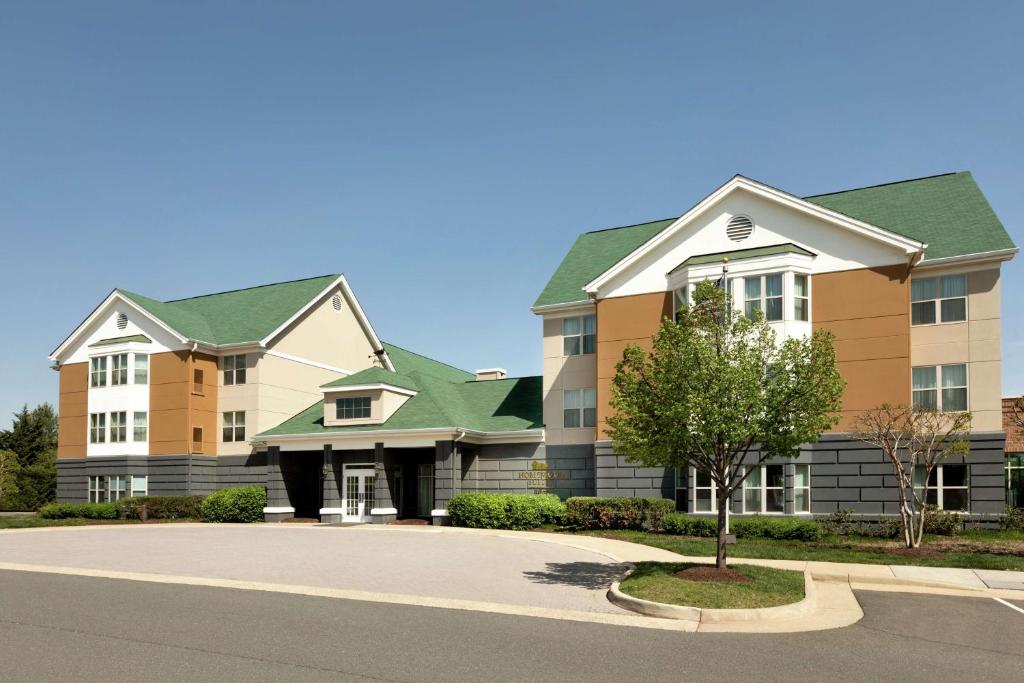 un gran edificio de apartamentos con un árbol en la entrada en Homewood Suites by Hilton Dulles-North Loudoun, en Ashburn