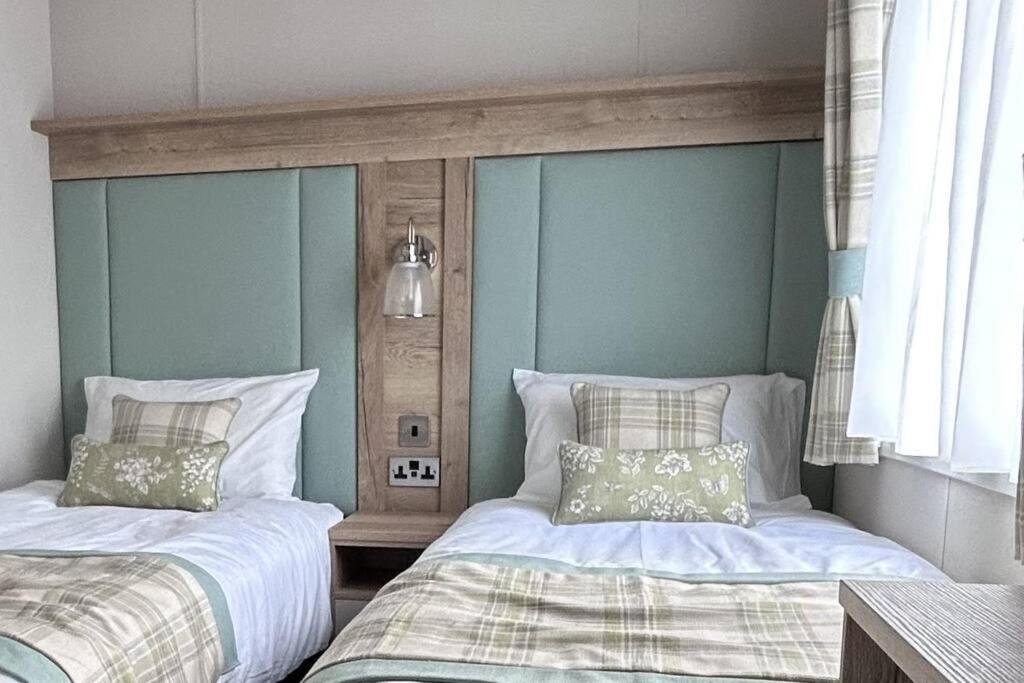 two beds sitting next to each other in a bedroom at Sandy Toes, Padstow in Padstow