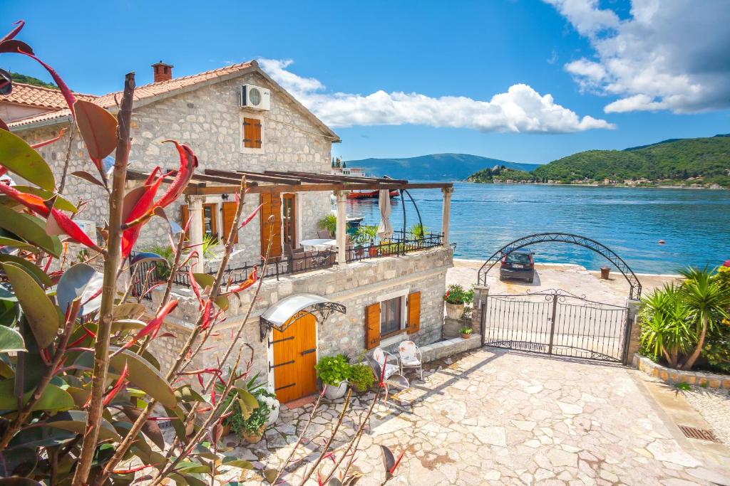 a house on the shore of a body of water at Apartments Villa Serventi in Tivat