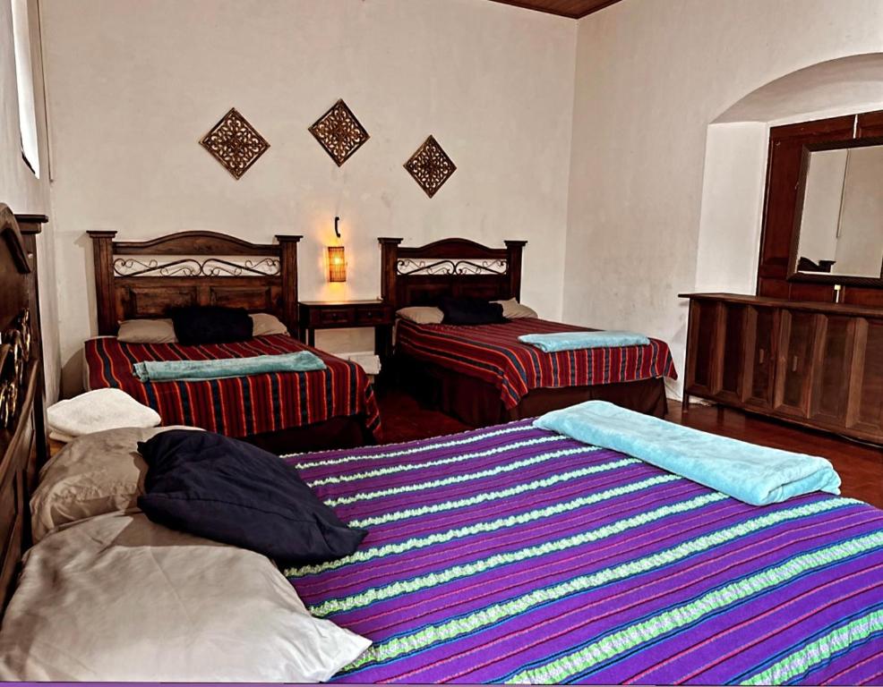 um quarto com duas camas num quarto em El Extranjero Hostal em Antigua Guatemala