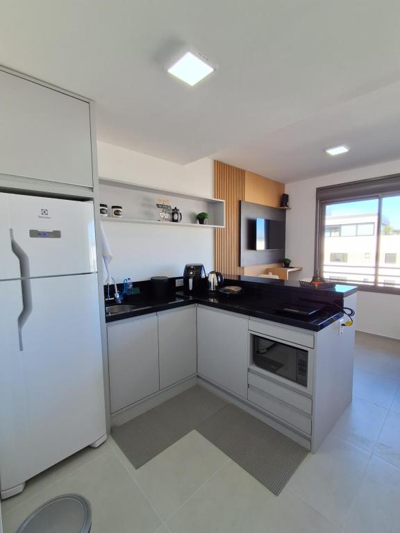 een keuken met witte apparatuur en een witte koelkast bij Lindo Studio NOVO no JP Redenção - Rofftop com vista espetacular in Porto Alegre