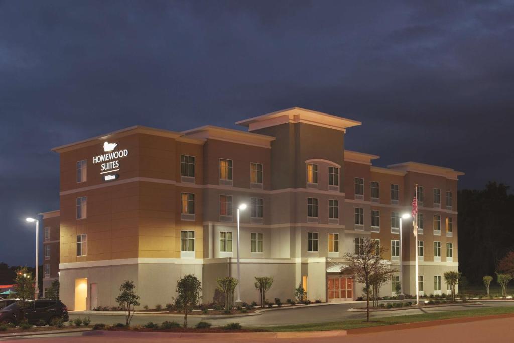 a hotel building with a sign on it at night at Homewood Suites Mobile in Mobile