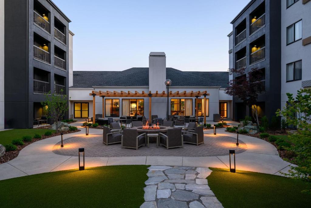 um pátio com mesas e cadeiras em frente a dois edifícios em Courtyard Boise Downtown em Boise