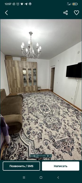 Квартира في Tridtsatʼ Let Kazakhstana: غرفة معيشة مع أريكة وثريا