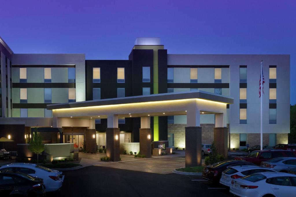 een gebouw met auto's geparkeerd op een parkeerplaats bij Home2 Suites by Hilton Louisville East Hurstbourne in Louisville