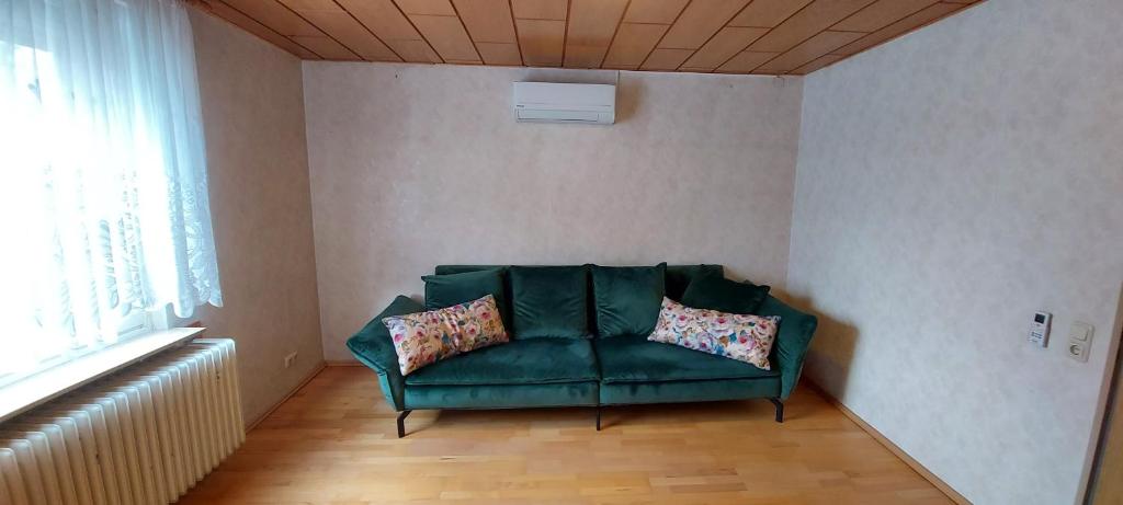 a green couch in a room with a window at Apartment Popp Langen in Langen