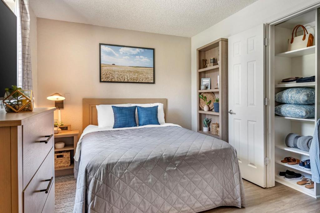 a bedroom with a bed with blue pillows at InTown Suites Extended Stay Fort Myers FL in Fort Myers