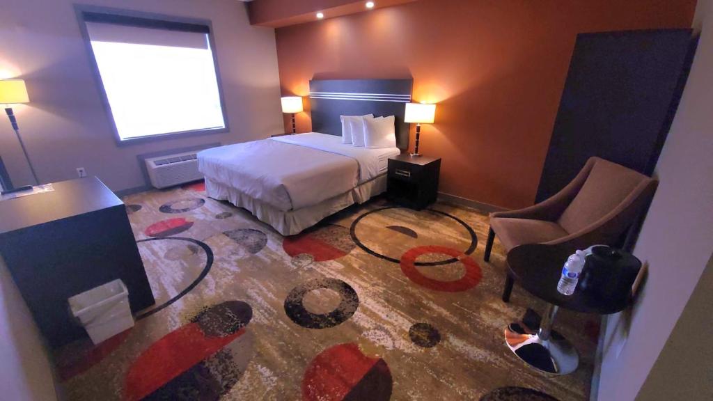 une chambre d'hôtel avec un lit et une chaise dans l'établissement Wabasca Inn, à Wabasca