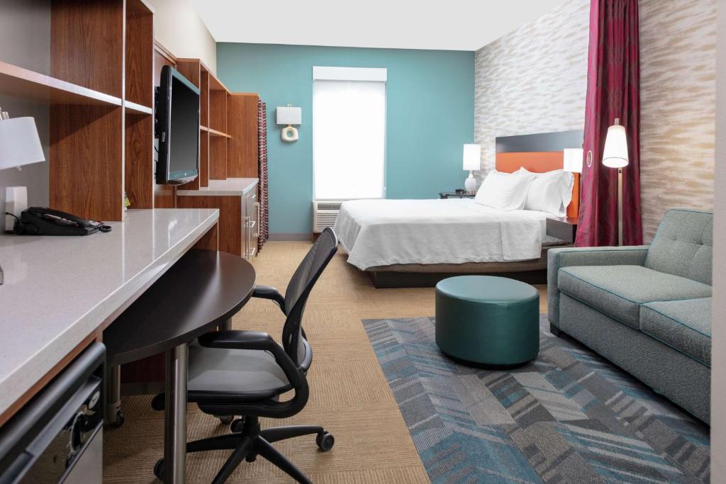 Cette chambre comprend un lit et un bureau. dans l'établissement Home2 Suites by Hilton Fayetteville, NC, à Fayetteville