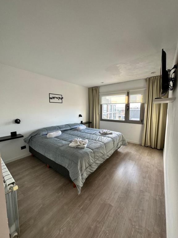 a bedroom with a bed and a large window at Depto 3 amb zona Guemes con cochera, balcón a la calle con parrilla a gas in Mar del Plata