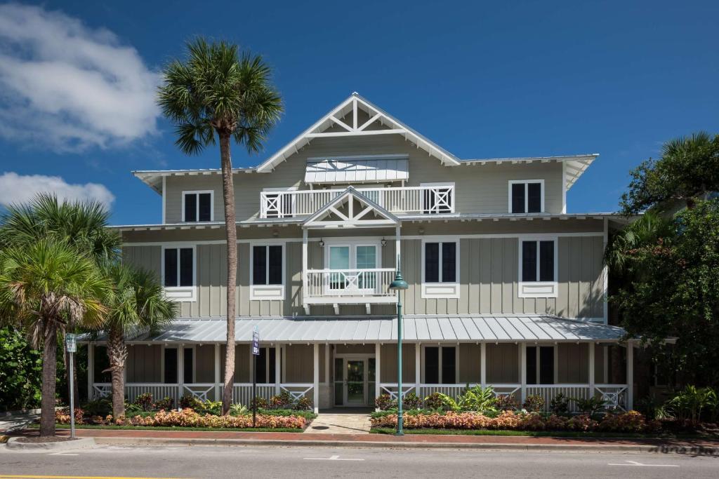 a large white building with palm trees in front of it at Hampton Inn New Smyrna Beach in New Smyrna Beach