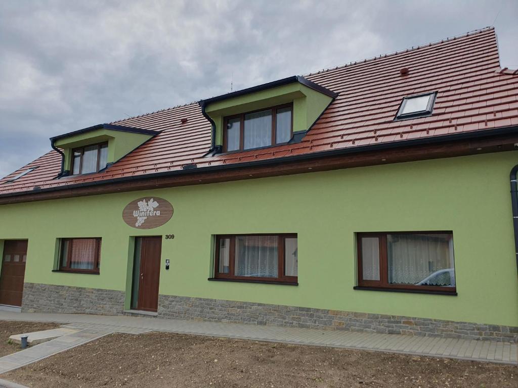 巴甫洛夫的住宿－Winifera Penzion，一座带红色屋顶的绿色房子