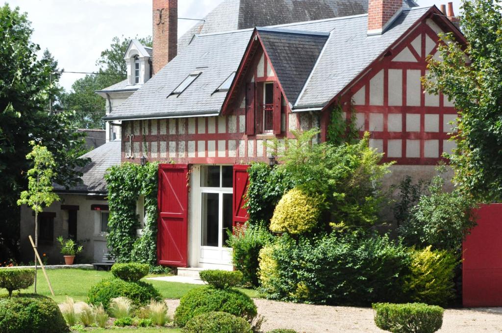 a red and white house with a black roof at La Halte du Clos in Cour-Cheverny