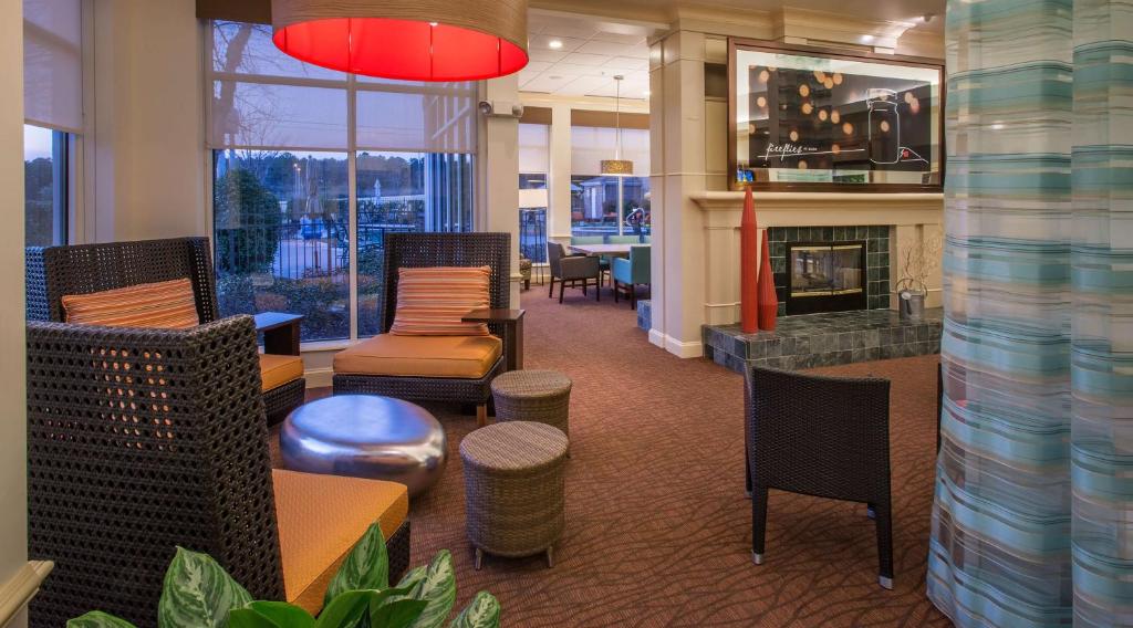 a lobby with chairs and a fireplace in a office at Hilton Garden Inn Huntsville/Space Center in Huntsville