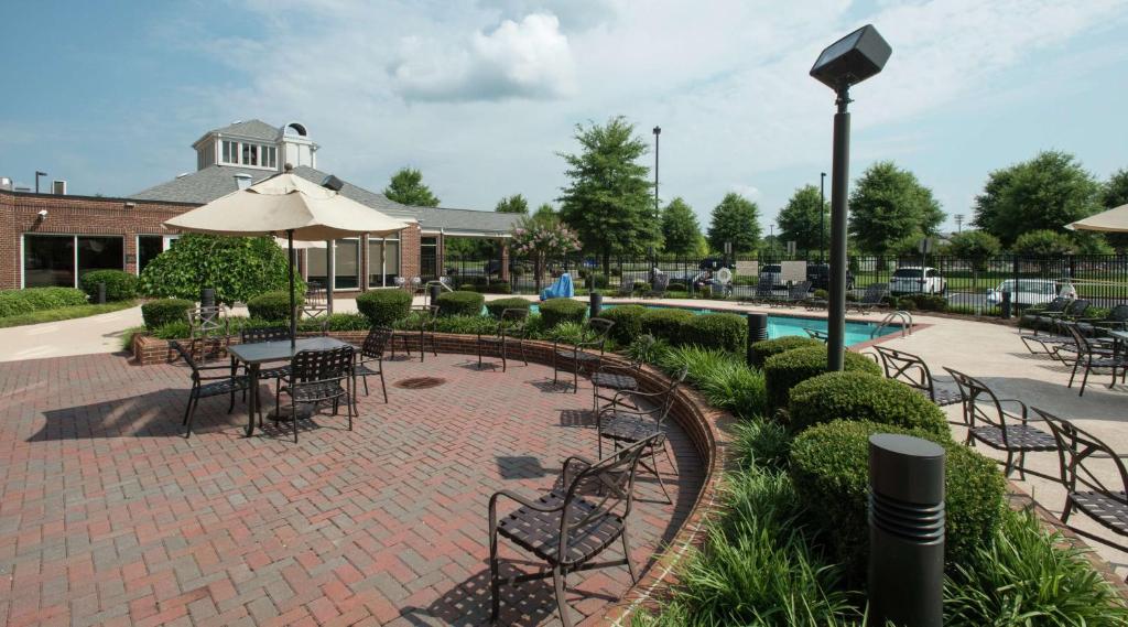 un patio con mesas y sillas y una piscina en Hilton Garden Inn Macon/Mercer University, en Macon