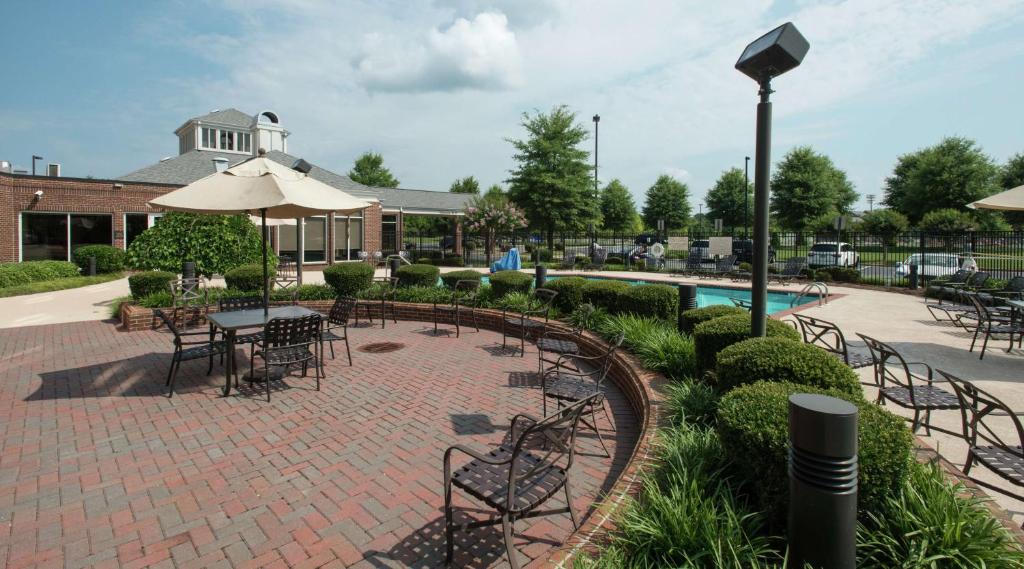 a patio with tables and chairs and a pool at Hilton Garden Inn Macon/Mercer University in Macon