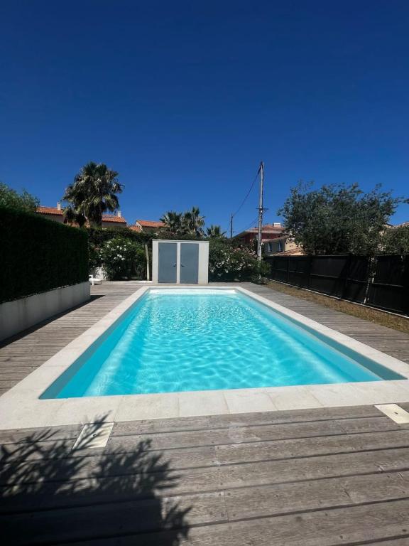 une piscine avec de l'eau bleue dans une cour dans l'établissement Les Cigales, à Antibes