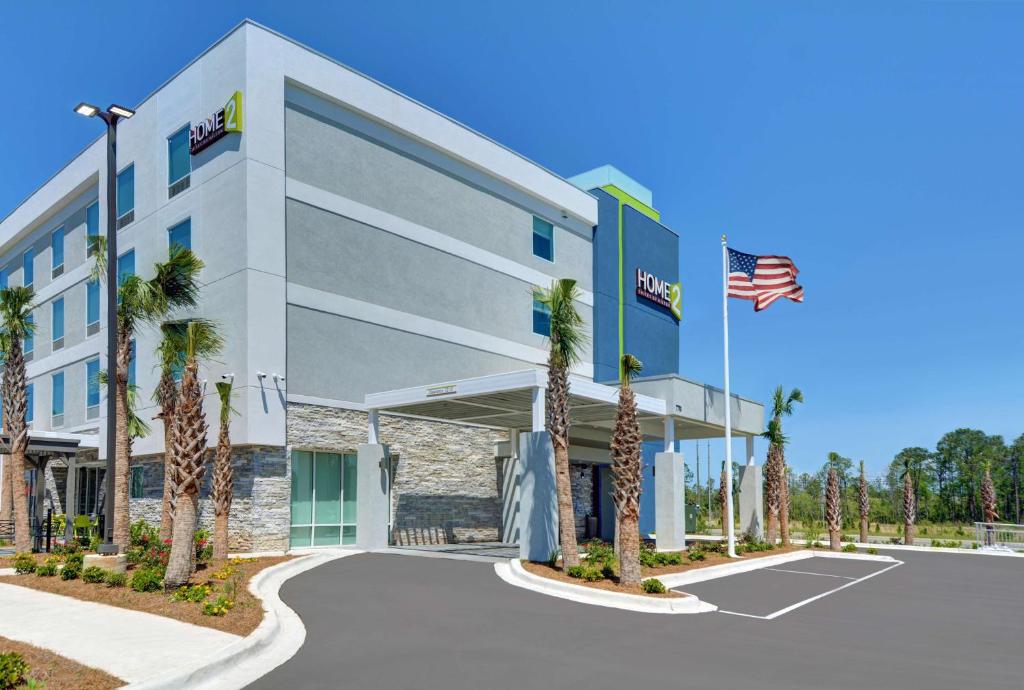 a rendering of the front of a hotel with palm trees at Home2 Suites By Hilton Panama City Beach, Fl in Panama City Beach