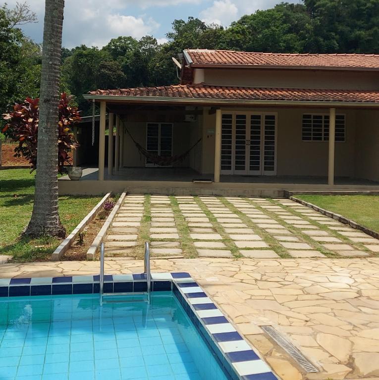 a house with a swimming pool in front of a house at Sitio Chacara temporada Lindoia Villa Vale in Lindóia