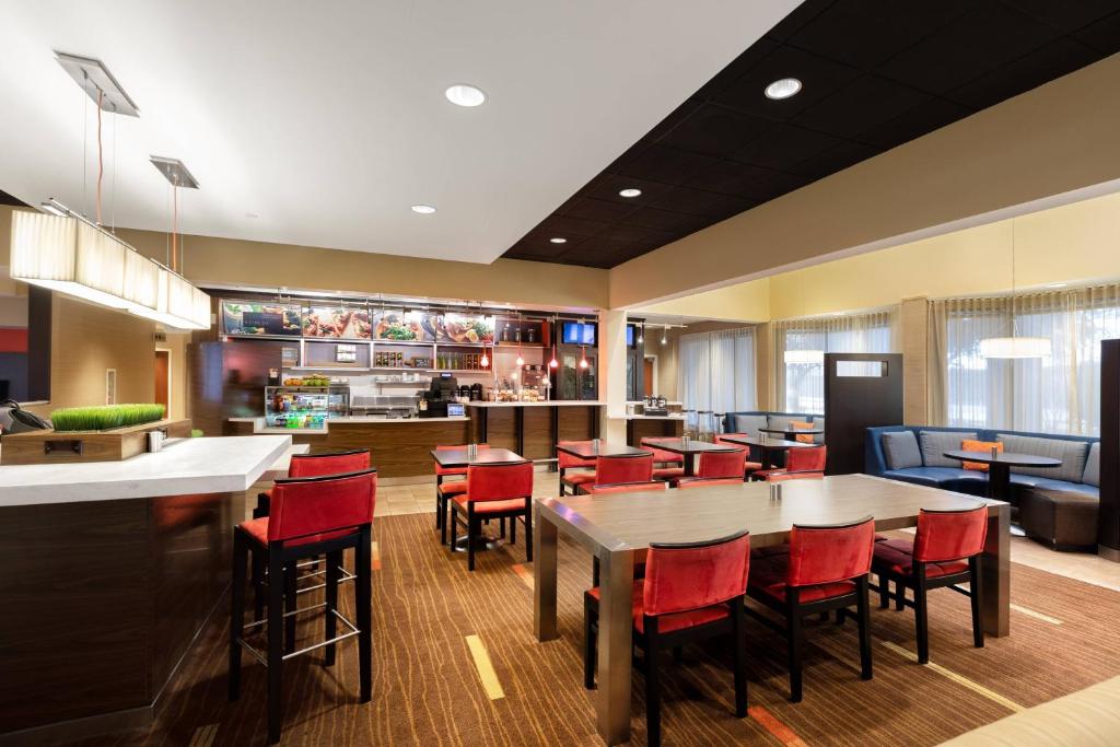 um restaurante com cadeiras e mesas vermelhas e um bar em Courtyard by Marriott Dallas-Fort Worth/Bedford em Bedford