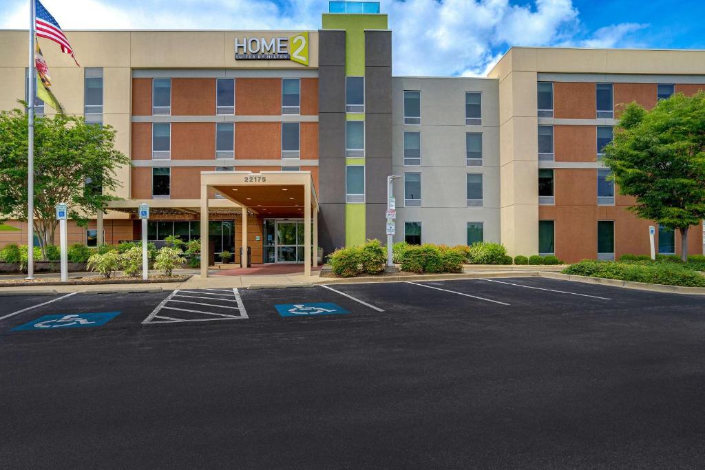 un edificio de oficinas con un estacionamiento delante de él en Home2 Suites by Hilton Lexington Park Patuxent River NAS, MD, en Lexington Park