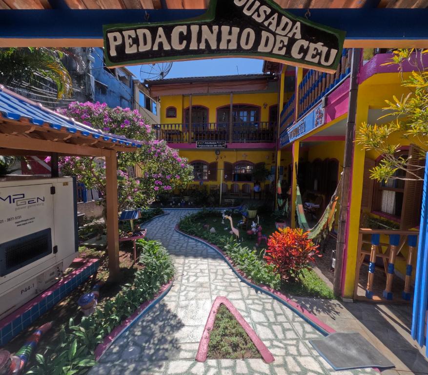 a walkway in a resort with a sign that reads peoriaoria becé at Pousada Pedacinho de Céu in Abraão