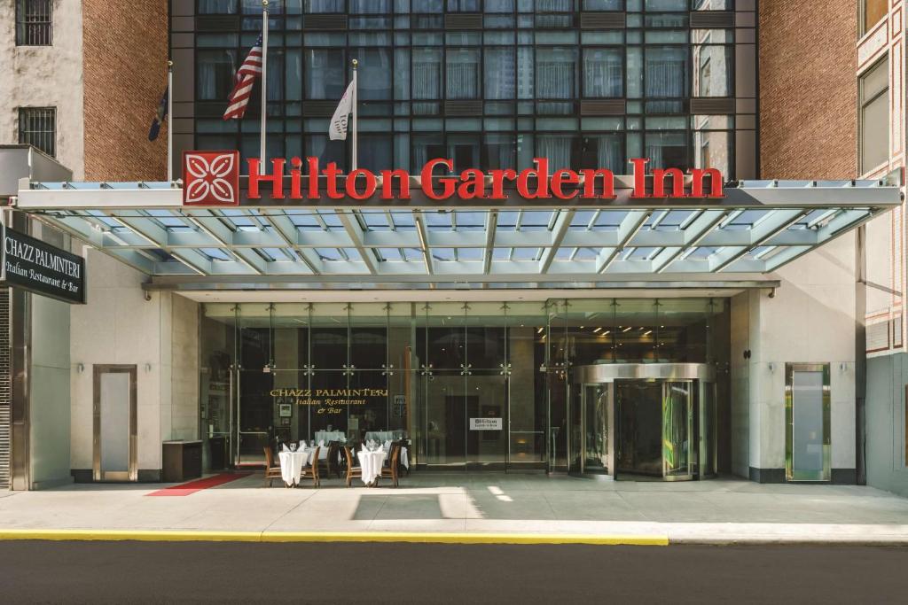 uma placa de Hilton Garden Inn em frente a um edifício em Hilton Garden Inn New York Times Square North em Nova York