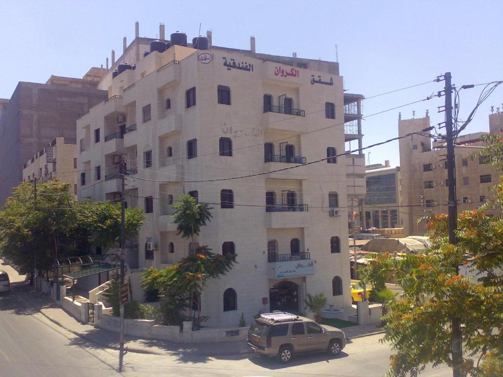 a building with a car parked in front of it at Al Karawan Hotel Apartments in Amman