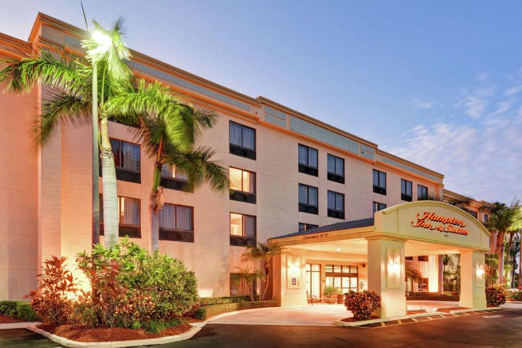 博因頓海灘的住宿－博因頓海灘希爾頓恆庭旅館&套房酒店，一座建筑前有棕榈树的酒店