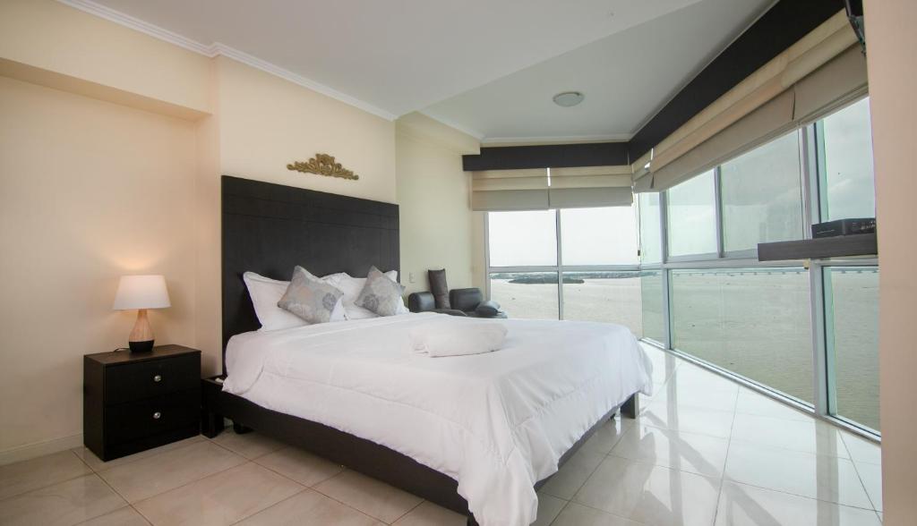 sypialnia z dużym łóżkiem i dużym oknem w obiekcie Departamento Riverfront 2, Puerto Santa Ana, Guayaquil w mieście Guayaquil