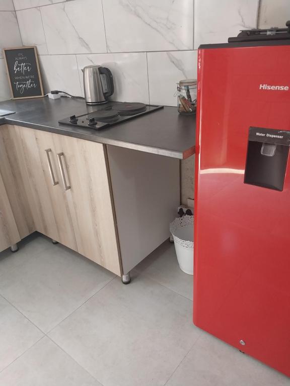 a red refrigerator in a kitchen with a counter at Comfort place 3 in Pretoria