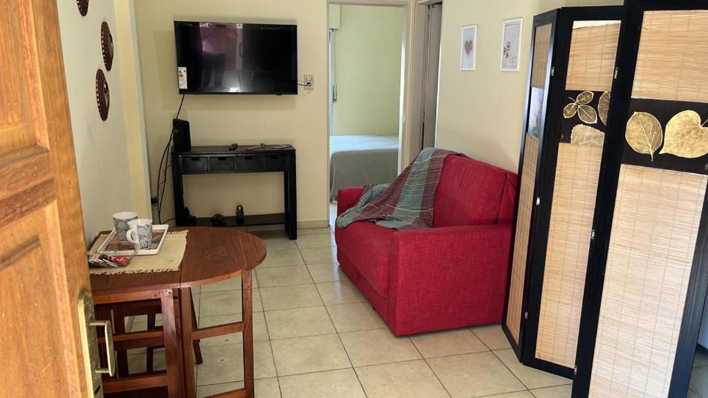 a living room with a red chair and a table at Dpto Centrico cerca de hospital escuela y facultad de medicina in Corrientes