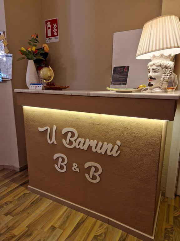 a hotel reception desk with a sign that says i barrington bc at U Baruni B&B in Messina