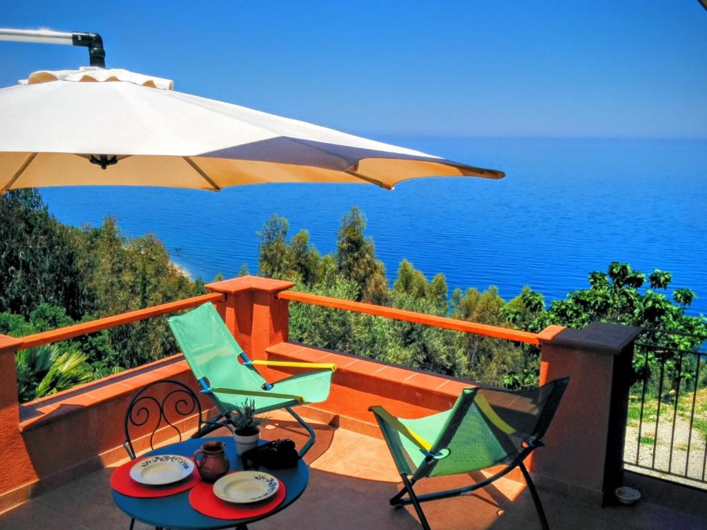 a patio with a table and chairs and an umbrella at Terramare in Castel di Tusa