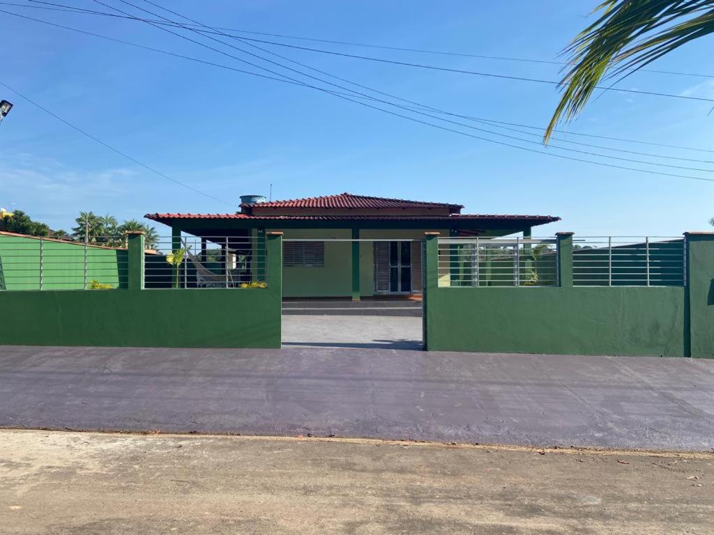 a green building with a roof on a street at Residencial das Cachoeiras in Presidente Figueiredo