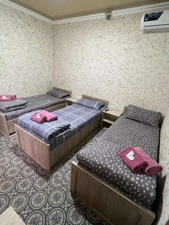 um quarto com três camas num quarto em Asia Minor em Samarcanda